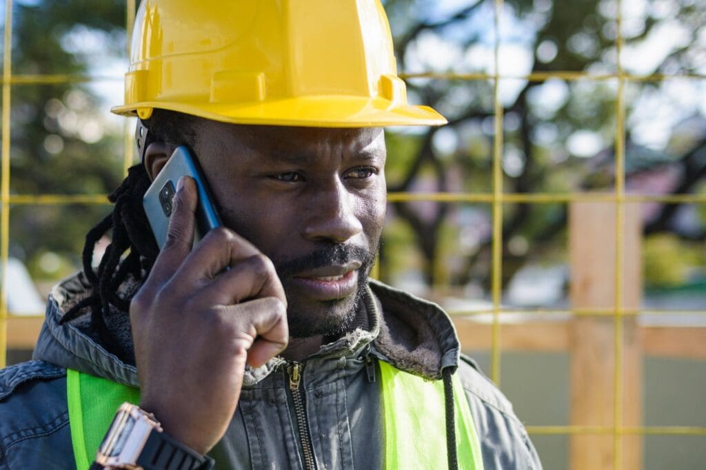 young black man builder at the construction site talking on the phone